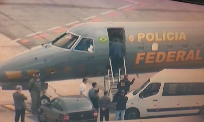 Palocci desce da van e embarca no avião da Polícia Federal com destino a Curitiba.